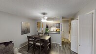 Located at 2534 Central Dr in Bedford, Texas, this single-floor residence offers a thoughtfully designed layout that balances comfort and functionality. The open-concept dining area flows seamlessly into the kitchen, connected via a convenient pass-through counter. The dining space features wood-look flooring, a ceiling fan with light fixture, and wall art that adds a contemporary touch. The kitchen is equipped with dark cabinetry, light quartz-style countertops, a subway tile backsplash, black appliances including an electric range and built-in microwave, and ample cabinet storage. The living room provides a welcoming atmosphere with wood-look flooring, a large sliding glass door that invites natural light, and generous wall space for artwork. The bedrooms are carpeted for comfort, each featuring ceiling fans, windows with blinds and curtains, and neutral wall tones that create a calm, restful environment. The bathroom includes a full tub-shower combination with a curved curtain rod, complemented by neutral gray tones throughout. The textured ceilings are consistent across the unit, adding a classic residential character. Overall, this residence presents a cohesive, neutral palette that offers a versatile and move-in-ready living space.