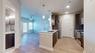 This 2-bedroom, 2-bathroom single-story residence offers a thoughtfully designed layout with modern finishes throughout. The open-concept kitchen and living area serves as the heart of the home, featuring light wood-tone flooring, recessed lighting, and a ceiling fan. The kitchen is well-equipped with dark espresso cabinetry, granite countertops, a subway tile backsplash, stainless steel appliances, and a center island with a built-in sink and pendant lighting overhead — ideal for both cooking and casual dining.

The living area extends naturally from the kitchen, bathed in natural light from multiple windows with horizontal blinds. The primary bedroom is generously sized, with wood-style flooring, a ceiling fan, and a window for natural light. Its en-suite bathroom features a walk-in shower with floor-to-ceiling tile, a granite-topped vanity, and direct access to a walk-in closet. The second bedroom features soft carpeting and a window, offering a comfortable and quiet retreat. The second bathroom includes a tiled soaking tub with a shower, a granite vanity, and tile flooring. A dedicated closet provides additional storage, completing this clean and contemporary residence.