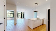 Located at 248 Tioronda Avenue in Beacon, NY, this thoughtfully designed 1-bedroom, 2-bathroom residence offers a contemporary living experience across a single, well-appointed floor. The open-concept layout seamlessly connects the kitchen and living areas, creating a bright and airy atmosphere enhanced by recessed lighting and striking black-framed floor-to-ceiling windows that frame verdant tree views throughout.

The modern kitchen serves as the centerpiece of the main living area, featuring a large white quartz waterfall island with an undermount sink and matte black faucet, sleek white cabinetry extending to the ceiling, and a full suite of stainless steel appliances including a refrigerator, range, and microwave. Pendant lighting adds a refined touch above the island.

The spacious primary bedroom opens directly to a private balcony through oversized black-framed glass doors, flooding the room with natural light and offering seamless indoor-outdoor connectivity. Additional rooms throughout the unit are equally bright, each featuring large grid-pane windows with lush outdoor views and light wood-tone flooring.

Both bathrooms are finished in neutral tile with modern fixtures, including an LED-lit vanity mirror and a soaking tub with shower combination. Four well-organized closets provide generous storage, and an in-unit laundry room adds everyday convenience.
