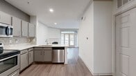 Located on the iconic South Congress Avenue in Austin, TX, this one-bedroom, one-bathroom residence offers a well-designed, efficient layout across a single floor. Wood-look flooring flows throughout, creating a cohesive and modern aesthetic.

The open-concept kitchen and living area serves as the heart of the space. The kitchen is outfitted with stainless steel appliances — including a refrigerator, electric range, microwave, and dishwasher — complemented by gray cabinetry, a mosaic tile backsplash, and a white peninsula countertop that provides additional workspace and casual dining potential. Recessed lighting illuminates the area.

The living room is a standout, anchored by a white-mantled fireplace and framed by tall French doors with transom windows above, allowing abundant natural light and offering a connection to the outdoors.

The bedroom is a comfortable, well-proportioned room featuring wood-look flooring, a ceiling fan with light fixture, and a window with blinds that brings in natural light. A dedicated closet provides practical storage.

The bathroom is clean and functional, with wood-look tile flooring, a vanity, and crisp white walls. A separate closet space adds further storage convenience to the overall floor plan.