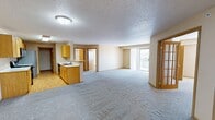 This well-designed single-story home in Fargo, North Dakota offers 1360 square feet of comfortable living space. The layout includes three bedrooms, with a generous 270 square foot primary bedroom, and two full bathrooms. The home's functional design features a dedicated laundry room with modern appliances and built-in storage shelving.

The kitchen is a highlight, boasting a galley-style layout with ample counter space, honey-toned wood cabinetry, and a full suite of appliances. Light wood flooring in the kitchen transitions seamlessly to plush carpeting in the living areas and bedrooms, creating a cohesive and inviting atmosphere throughout.

Large windows in the living room and bedrooms allow for abundant natural light, enhancing the sense of spaciousness. The bathrooms are well-appointed, featuring tiled floors, vanities with storage, and combination tub-shower units. One bathroom includes a corner jacuzzi tub for added luxury.

The open floor plan creates a flowing connection between the living spaces, ideal for both everyday living and entertaining. With its practical layout and comfortable finishes, this home offers a balance of functionality and comfort in a desirable Fargo location.