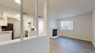 Located at 10775 E Virginia Ave in Aurora, CO, this one-bedroom, one-bathroom unit offers a practical and well-designed single-floor layout. The living room serves as the heart of the space, featuring light hardwood-style flooring, a textured ceiling, a large window that lets in natural light, and a classic white-mantled fireplace that adds a warm, inviting focal point. The kitchen is thoughtfully laid out in a galley style, with white cabinetry, light stone-look countertops, stainless steel appliances including a refrigerator and electric range, and a stainless steel sink — all illuminated by a ceiling-mounted light fixture. A set of decorative columns visually separates the kitchen from the living area while maintaining an open feel. The bedroom is comfortably sized, featuring soft carpeting, a textured ceiling, and a window with vertical blinds that allow for adjustable natural light. It connects directly to a spacious walk-in closet outfitted with dual shelving rods and shelves on both sides, providing generous storage. The bathroom is clean and bright, with a tub-shower combination, a window for natural ventilation, and light hardwood-style flooring. A connecting hallway ties the layout together cohesively, completing this efficient and move-in ready home.