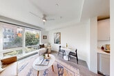 Located at 312 W Republican St in Seattle's desirable Queen Anne neighborhood, this one-bedroom, one-bathroom residence offers a thoughtfully designed layout that maximizes every square foot. The open living area is anchored by a large floor-to-ceiling window that floods the space with natural light and frames views of the surrounding urban greenery. A ceiling fan adds functionality to the bright, white-walled interior, while light wood-tone flooring runs throughout, lending warmth and visual continuity. The living room comfortably accommodates both a seating area and a compact dining space, with a seamless opening to the kitchen, which features light cabinetry, built-in appliances including a stainless steel refrigerator and oven, and efficient counter space. The bedroom is a serene, well-proportioned retreat with soft neutral tones, dual bedside lighting, and access to a dedicated closet. A hallway connects the bedroom to the rest of the unit, providing a sense of separation and privacy. The bathroom is clean and minimalist, finished with light wood-look flooring and crisp white walls. Throughout the unit, the design aesthetic is consistently modern and understated, creating a calm, cohesive living environment well-suited for urban living in Seattle.