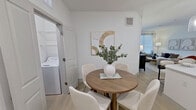 Located at 13959 Hillcroft Ave in Houston, TX, this 1,070 sq ft apartment delivers a clean, modern aesthetic across three bedrooms, two bathrooms, and one cohesive floor. The open-concept kitchen and living area serves as the heart of the home, featuring dark wood-grain cabinetry, white quartz countertops, a subway tile backsplash, stainless steel appliances, and a large island with pendant lighting and bar seating. A built-in desk nook adjacent to the kitchen provides a convenient workspace. The living room offers large windows with abundant natural light and direct access to an exterior door. Light wood-tone flooring flows throughout the unit, enhancing the bright, airy atmosphere. The primary bedroom measures 160 sq ft and includes dual closets with double-panel doors. Secondary bedrooms feature ceiling fans and large windows with blinds. Both bathrooms are finished with dark wood vanities, white quartz sinks, and wall-mounted storage cabinets. One bathroom includes a soaking tub with tile surround, while the other features a shower. A dedicated laundry room with a side-by-side washer and dryer adds everyday convenience. A hallway and closet complete the well-organized layout.