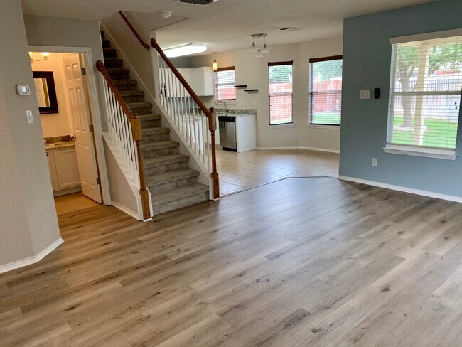 Living area open to dining room and kitchen w/ half bath on first floor - 10219 Roseangel Ln
