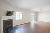 This well-designed two-story home at 8445 Carson Pl offers four bedrooms and three bathrooms across two thoughtfully laid-out floors. The main level sets a welcoming tone with a tile-floored living room anchored by a striking marble-surround fireplace with a classic white mantle, complemented by crown molding and natural light from a large window. The galley-style kitchen is a standout, featuring rich granite countertops, cream-toned raised-panel cabinetry, stainless steel appliances including a gas range and dishwasher, recessed lighting, and tile flooring — all opening conveniently toward the garage. The attached two-car garage offers generous space with an automatic opener. Upstairs, the expansive primary bedroom provides a generous retreat, while additional bedrooms feature light hardwood-style flooring and windows with views of the surrounding neighborhood. The bathrooms are finished with granite double-vanity countertops, tile flooring, and a glass-enclosed shower-tub combination. A bright, open bonus room on the upper level with recessed lighting and hardwood-style floors adds flexible living space. Throughout, neutral tones, crown molding, and consistent finishes create a cohesive and move-in-ready atmosphere.