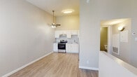 This efficiently designed 2-bedroom, 1-bathroom unit offers a well-organized single-floor layout that maximizes every inch of available space. Light wood-style luxury vinyl flooring runs throughout, lending a clean, cohesive look to the entire unit.

The open living and kitchen area forms the heart of the home, anchored by a ceiling fan with lighting that enhances air circulation and ambiance. The kitchen is outfitted with white shaker-style cabinetry, light countertops, a stainless steel electric range, dishwasher, and refrigerator, all set against a neutral wall palette. A single-basin sink and under-cabinet range hood complete the functional cooking space.

The primary bedroom is generously sized, featuring two windows dressed with horizontal blinds that allow for natural light and privacy control. The second bedroom offers a quiet, neutral space with the same consistent flooring and warm wall tones.

The bathroom is clean and straightforward, featuring a full tub-shower combo with white tile surround, a toilet, and wood-style flooring that ties in with the rest of the unit. An in-unit laundry area adds everyday convenience.

Overall, the space presents a bright, move-in-ready layout with a neutral color scheme and updated finishes throughout, making it a practical and comfortable living option.
