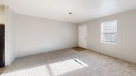 Located at 2534 Lumpkin Rd in Augusta, Georgia, this single-floor home offers a straightforward, functional layout with consistent design elements throughout. The kitchen is a standout area, equipped with a black electric range, an overhead ventilation hood, and striking granite countertops with a white and gray pattern. Crisp white cabinetry with brushed nickel hardware lines the walls, providing ample storage while contributing to a clean, bright aesthetic. The bedrooms feature neutral carpet flooring and distinctive vertical panel walls painted in soft white and light gray tones, lending a subtle texture to the interiors. Crown molding accents the ceilings, adding a refined touch. Windows fitted with horizontal blinds allow natural light to filter into the rooms, creating a comfortable and welcoming atmosphere. The bathroom includes a full-size soaking tub and shower combination with a white surround, chrome fixtures, and a towel bar, reflecting a simple and practical design. The entry area transitions from carpeted living space to durable wood-look flooring near the front door. Overall, the home presents a clean, well-maintained interior with cohesive neutral tones and functional finishes throughout its single-floor footprint.