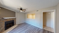 Located at 9608 Meandering Way in Fort Smith, Arkansas, this single-story 2-bedroom, 2-bathroom home offers a well-organized layout across a comfortable footprint. The living room serves as the heart of the home, highlighted by a striking stone-accented fireplace with a shiplap-style surround, wood-look flooring, a textured ceiling, and a ceiling fan with light. A sliding glass door allows natural light to pour in and provides outdoor access. A pass-through window connects the living area to the kitchen, enhancing the open feel between spaces. The kitchen includes a pantry and connects to the dining area, creating a practical flow for daily living. Both bedrooms feature wood-look flooring, ceiling fans, and closets, with natural light provided by windows with blinds. The primary bedroom offers a comfortable, private retreat. The two bathrooms are finished with large-format tile in a neutral marble-inspired pattern, each equipped with a tub-shower combination. A dedicated laundry area with overhead cabinetry and tile flooring adds everyday convenience. The home also includes three closets, a hallway, and consistent neutral tones throughout, creating a clean and cohesive interior aesthetic.