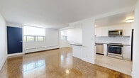 Located on the 9th floor at 739 Birchmount Road in Toronto's Scarborough district, this one-bedroom, one-bathroom unit offers a well-organized layout across a single floor. The open living room is bright and airy, featuring warm parquet flooring and large windows that flood the space with natural light while framing expansive views of the surrounding cityscape. A sliding glass door leads to a private balcony enclosed by sleek glass-panel railings, offering unobstructed panoramic views of the Toronto skyline and greenery below. The kitchen is thoughtfully designed with white shaker-style cabinetry, dark countertops, a herringbone tile backsplash, and a full suite of stainless steel appliances including a dishwasher, stove, microwave, and refrigerator. Light tile flooring completes the clean, modern aesthetic. The bedroom is a comfortable, well-proportioned space with the same parquet flooring found throughout and a mirrored sliding-door closet. The bathroom features classic white subway tile surrounding a full soaker tub, complemented by a dark-toned vanity and neutral tile flooring. A hallway connects all areas efficiently, completing this functional and well-appointed urban residence.