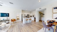 Located in Palm Desert, CA, this well-appointed 2-bedroom, 2-bathroom single-story residence offers a thoughtfully designed open-concept layout with light wood-style flooring throughout the main living areas. The bright living room features large windows that invite abundant natural light, a ceiling fan, and direct views of the surrounding landscape, creating an airy and welcoming atmosphere.

The kitchen is outfitted with white shaker cabinetry, quartz countertops, a subway tile backsplash, and a full suite of stainless steel appliances including a gas range, microwave, refrigerator, and dishwasher. A central island with bar seating adds both prep space and a casual dining option. An in-unit washer and dryer area is conveniently accessible from the kitchen.

Both bedrooms are carpeted and comfortably sized, each with ceiling fans and generous closet space. The primary bedroom includes a spacious walk-in closet. The two bathrooms feature white cabinetry, quartz countertops, and wood-style tile flooring. The primary bath includes a wide vanity with dual-sink capability, while the second bath offers a full tub and shower combination. A hallway connects the bedrooms and bathrooms, completing the functional single-floor layout.