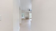 This thoughtfully designed 2-bedroom, 2-bathroom home in Austin, TX offers a clean, modern aesthetic throughout its single-floor layout. The open-concept living room and kitchen area is anchored by light wood-look flooring, a ceiling fan, and multiple windows that flood the space with natural light. Built-in shelving and a lower cabinet unit add functional storage to the living area, which also features access to an outdoor space via a sliding glass door.

The kitchen is well-appointed with stainless steel appliances, including a full-size refrigerator and range, white shaker-style cabinetry, a subway tile backsplash, and a striking marble-look quartz peninsula with a matte black faucet — ideal for both cooking and casual dining.

Both bedrooms feature plush carpeting and ceiling fans, with the primary bedroom offering a generous footprint and direct access to its en-suite bathroom. The bathrooms are finished with marble-look tiled tub-shower surrounds, white quartz vanity countertops, and sleek matte black hardware and fixtures.

Additional highlights include two closets, a dedicated entrance, and a connecting hallway. The overall palette of crisp whites and light neutrals creates a bright, cohesive ambiance throughout the home.
