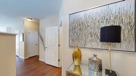 This single-floor residence offers a thoughtfully designed layout that balances open communal spaces with comfortable private retreats. The entryway sets an elegant tone, featuring rich hardwood flooring, white panel doors, and a console table that creates a welcoming first impression.

The open-concept kitchen is a standout feature, showcasing rich cherry wood cabinetry, granite countertops, and stainless steel appliances including a range, microwave, and dishwasher. A peninsula with pendant lighting and bar seating connects seamlessly to the dining area and living room, which benefits from abundant natural light through multiple windows fitted with blinds.

The living room provides a relaxed atmosphere with hardwood floors and ample wall space. Two carpeted bedrooms offer comfortable retreats, each featuring natural light from windows and warm neutral tones. One bedroom includes an en-suite bathroom with a glass-enclosed walk-in shower and hardwood floors, while a second full bathroom offers a tub-shower combination with granite vanity and wood cabinetry.

A dedicated laundry room includes a utility sink, wire shelving, and washer/dryer hookups, adding valuable functionality. Throughout the residence, neutral warm tones, consistent finishes, and a cohesive design create a polished, inviting ambiance.