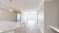 Located at 1030 Jack Primus Rd in Charleston, SC, this well-appointed 2-bedroom, 2-bathroom residence offers a thoughtfully designed single-floor layout. The open-concept living and kitchen area forms the heart of the home, where light wood-style flooring, crown molding, and a ceiling fan create a bright and airy atmosphere. A large window draws in natural light, enhancing the sense of spaciousness throughout.

The kitchen is a standout feature, showcasing white shaker cabinetry extending to the ceiling, a classic subway tile backsplash, stainless steel appliances, and a generous granite-topped peninsula ideal for dining or entertaining. Pendant lighting adds a polished finishing touch.

Both bedrooms are carpeted for comfort and include ceiling fans and windows with natural light. The primary bedroom is a comfortable size and connects to an en-suite bathroom with walk-through access to a dedicated walk-in closet outfitted with wire shelving. The second bathroom features a full tub-shower combo, stone-topped white vanity, and wood-look tile flooring. Two closets provide ample storage throughout the home. The neutral color palette and clean finishes give the space a modern, move-in-ready appeal.