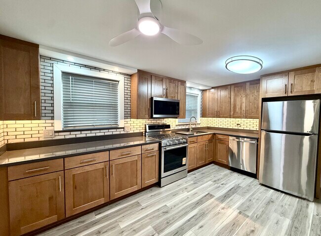 ¡Cocina totalmente remodelada con gabinetes nuevos, encimeras de cuarzo, electrodomésticos de acero inoxidable y pisos de tablones macizos! - 16W671 56th St