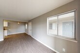 Located at 313 Sandy Ln in Suisun City, CA, this one-bedroom, one-bathroom home offers a well-organized, single-floor layout designed for comfortable everyday living. The open living and dining areas are finished with durable wood-style flooring and neutral gray walls, creating a clean, modern aesthetic throughout. Natural light filters in through multiple windows fitted with horizontal blinds, lending the common areas a bright and airy feel. A sliding glass door in the living room provides direct access to an outdoor patio area. The galley-style kitchen is well-appointed with white shaker cabinetry, granite-look countertops, stainless steel appliances including a refrigerator, and a built-in range with overhead ventilation — all set on light-toned flooring. The bedroom offers plush carpeting, a dedicated closet, and a window with outdoor views. The bathroom features wood-style tile flooring, a tub/shower combo, and clean white fixtures. Additional highlights include a dedicated laundry area, utility spaces, and a ceiling fan in the living area. The overall design emphasizes functionality and a neutral, move-in-ready palette throughout the home.