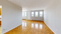 Located on the 8th floor at 1920 Weston Rd in Toronto's Weston neighbourhood, this one-bedroom, one-bathroom unit offers a practical and comfortable layout. The living room is the heart of the space, featuring gleaming parquet wood flooring in a classic herringbone-style pattern that extends throughout the unit. Multiple windows line the walls, flooding the room with natural light and offering pleasant outdoor views of the surrounding area. Baseboard heating runs along the exterior walls, ensuring warmth throughout the seasons. The bedroom is a well-proportioned room with the same warm parquet flooring, a large double closet with sliding doors, and windows that bring in additional natural light. The kitchen is equipped with warm-toned wood cabinetry reaching to the ceiling, a double stainless steel sink, laminate countertops with a tile backsplash, and a full-size refrigerator, providing ample storage and functionality. The bathroom features a full bathtub and shower combination with marble-style tile surround, a toilet, and a vanity with sink, all set on light wood-look flooring. The unit's neutral grey walls and consistent flooring throughout create a cohesive and clean aesthetic.