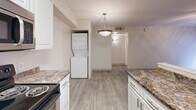 Located on W Speedway Blvd in Tucson, Arizona, this one-bedroom, one-bathroom unit offers a well-organized single-floor layout designed for comfortable everyday living. Wood-look flooring runs throughout the home, lending a clean and cohesive aesthetic to every room.

The kitchen is a functional galley-style space outfitted with white shaker cabinetry, granite-style countertops, and stainless steel appliances including a refrigerator, electric range, and microwave. A stacked washer and dryer unit is conveniently integrated into the kitchen area, complemented by a pendant light that anchors the space.

The bedroom is a comfortable, naturally lit room featuring a ceiling fan with light fixture and a window dressed with horizontal blinds. The room connects to a spacious walk-in closet lined with dual-sided shelving and hanging rods, providing generous storage capacity.

The bathroom features a full tub-shower combo with white tile surround, wood-look flooring, and granite-style countertop finishes that echo the rest of the home. A hallway connects the living areas smoothly, contributing to the unit's efficient flow.

Throughout the home, neutral wall tones and consistent flooring create a bright, move-in-ready environment suited for a variety of lifestyles.