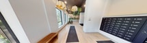 This 880 square foot single-floor space at 112 St James Street, London ON, showcases a stunning blend of modern design and nature-inspired elements. The interior is characterized by its biophilic approach, with an abundance of hanging plants cascading from the ceiling, creating a lush, green canopy overhead. Light wood flooring extends throughout, complementing the natural theme and adding warmth to the space.

The room features high ceilings with a dark accent, providing contrast to the predominantly white walls. Large windows allow ample natural light to flood the area, enhancing the overall brightness and spaciousness. Contemporary furniture, including uniquely shaped chairs in muted tones, adds a touch of sophistication.

A striking feature is the geometric accent wall, which adds visual interest and texture. The space incorporates built-in planters with thriving greenery, further blurring the lines between indoors and outdoors. Pendant lights with distinctive yellow shades hang from the ceiling, providing both illumination and artistic flair.

The layout appears to be open and fluid, with areas for seating and circulation clearly defined. Dark floor mats near the entrance offer practicality without compromising on style. This thoughtfully designed space successfully marries functionality with a serene, nature-inspired aesthetic, creating an environment that is both modern and calming.