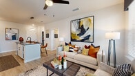 Located at 4665 Whitfield Ave in Sarasota, Florida, this thoughtfully designed single-floor residence offers a contemporary open-concept layout that seamlessly connects the kitchen, dining, and living areas. The kitchen is a standout feature, equipped with crisp white shaker cabinetry, dark hardware accents, quartz countertops, stainless steel appliances including a French door refrigerator and built-in microwave, a hexagonal tile backsplash, and a generous island with bar seating — ideal for casual dining and entertaining. The living area is bright and airy, with large windows fitted with blinds that invite abundant natural light and outdoor views, complemented by ceiling fans throughout. The primary bedroom is a serene retreat, carpeted for comfort, featuring multiple windows, and direct access to a spacious walk-in closet with wire shelving systems. The en-suite bathroom offers a clean, modern aesthetic with a frameless glass walk-in shower clad in large-format white tile. A second bedroom also includes its own walk-in closet. Wood-look plank flooring runs through the main living areas, adding warmth and continuity. A dedicated in-unit laundry room with full-size washer and dryer and overhead shelving adds everyday convenience to this well-appointed Sarasota residence.