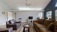 Located at 2800 Booty Dr in Columbus, Ohio, this single-floor home offers a comfortable and functional layout designed for everyday living. The living room serves as the heart of the home, showcasing durable hardwood-style flooring that runs throughout the space, lending warmth and a cohesive aesthetic. Neutral gray walls provide a clean, versatile backdrop, while a ceiling fan anchors the room from above, offering both style and practical airflow. Natural light filters in through windows fitted with blinds, brightening the open floor plan and creating an inviting atmosphere. The living area provides ample space for seating arrangements and entertainment, with clear sightlines that enhance the sense of openness. Doorways connect seamlessly to additional rooms, suggesting a straightforward and accessible floor plan. The additional rooms in the home, while dimly captured, include windowed spaces with blinds, indicating continued access to natural light throughout. Overall, this home presents a practical and well-maintained single-level living environment, well-suited for those seeking a straightforward, move-in-ready space in the Columbus, Ohio area.