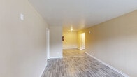 Located at 1012 33rd St SW in Birmingham, Alabama, this single-floor, one-bedroom, one-bathroom unit offers a practical and well-organized layout. The combined kitchen and living area greets you at the entry, featuring light gray wood-look flooring, warm beige walls, and a wall-mounted HVAC unit beneath a large window that brings in natural light. The kitchen is well-equipped with dark espresso-finish cabinetry, granite-look countertops, a black electric range, refrigerator, and a double basin sink — providing ample storage and functionality. The living area flows naturally from the kitchen, offering an open and versatile space. The spacious bedroom features plush carpeting, a ceiling fan with light fixture, a window with an outdoor view, and a sliding-door closet with a built-in rod for convenient storage. The full bathroom includes a dark vanity cabinet with a granite-look countertop and lighted mirror, a standard toilet, and a shower/tub combination, all finished with the same wood-look flooring found throughout the common areas. Clean white trim and neutral wall tones tie the entire space together, creating a cohesive and move-in ready environment.