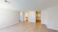 Located at 401 Talcottville Rd in Vernon Rockville, Connecticut, this single-floor, 2-bedroom, 2-bathroom residence offers a well-organized and functional layout. Light-toned luxury vinyl plank flooring flows consistently throughout the living areas and bedrooms, complemented by neutral gray-white walls and textured ceilings that create a clean, bright aesthetic.

The open living room provides a comfortable gathering space with a large window that invites natural light and offers views of the surrounding greenery. It connects seamlessly to the kitchen, which features a galley-style design with white shaker cabinetry, dark granite countertops, and a full suite of stainless steel appliances including a gas range, microwave, and refrigerator. A door at the end of the kitchen provides direct exterior access.

Both bedrooms are well-proportioned, with the spacious primary bedroom offering ample room and convenient access to one of the two bathrooms. The bathrooms are finished with dark granite-top vanities, white cabinetry, and stone-look tile flooring. One bathroom includes a window for natural ventilation. The residence also benefits from four closets distributed throughout, a dedicated utility room, and generous overall storage. The single-level layout ensures easy accessibility throughout.