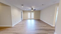 Located at 603 E Abbey Pl in Brandon, Mississippi, this single-story home offers three bedrooms, two bathrooms, and a thoughtfully designed layout across a comfortable footprint. The interior features wood-look luxury vinyl plank flooring throughout the main living areas, complemented by neutral warm-toned walls and clean white trim that create a bright, cohesive aesthetic.

The spacious living room is a standout space, anchored by a ceiling fan and French doors that invite natural light and provide outdoor access. A pass-through window with a granite-style countertop connects the living and dining area to the kitchen, which is outfitted with dark wood cabinetry, light granite countertops, a tile backsplash, stainless steel appliances including a range, microwave, and dishwasher, and light wood-look flooring.

The bedrooms are carpeted for comfort, each featuring ceiling fans and windows. The primary bedroom includes a walk-in closet. The bathrooms feature light wood cabinetry, granite-style countertops, and a tub-shower combination. A dedicated laundry room adds everyday convenience. A central hallway connects all rooms, lending the home a practical and organized flow.