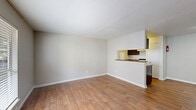 Located at 3700 Watonga Blvd in Houston, TX, this 2-bedroom, single-floor unit offers a practical and well-organized layout. Warm wood-style flooring flows consistently throughout the entire space, creating a cohesive and inviting atmosphere.

The living room is bright and open, featuring a large window with blinds that allows natural light to fill the space, alongside a front entry door. It connects seamlessly to the adjacent dining area, which opens to the kitchen via a peninsula-style pass-through bar with dark cabinetry and laminate countertops.

The galley kitchen is efficiently designed with dark lower and upper cabinets, laminate countertops, a stainless steel double sink, a white refrigerator, dishwasher, and electric range, complemented by a dedicated pantry for additional storage.

Both bedrooms are equipped with ceiling fans and natural light from windows. The primary bedroom includes a closet and direct access to a bathroom. A dedicated closet area within the unit also houses a stacked washer and dryer, adding convenience. The unit's neutral color palette and clean lines throughout provide a functional and comfortable living environment.