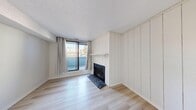 This two-storey, 2-bedroom, 1-bathroom home in Calgary, AB is thoughtfully laid out across two levels, offering a practical and comfortable floor plan. The main level hosts the entrance, living room, dining room, and kitchen. The living room is a standout space, featuring a wood-burning fireplace framed by white vertical shiplap-style paneling, light hardwood flooring, and a large sliding glass door that opens onto a private balcony, allowing ample natural light to fill the room. The kitchen and dining area provide functional everyday living spaces that flow naturally from one to the next. A staircase with a classic metal balustrade connects the two levels, adding a subtle decorative touch to the interior. The upper level houses both bedrooms, the full bathroom, a laundry room with a side-by-side washer and dryer, and additional hallway space. The bedrooms are bright and airy, each with windows overlooking the surrounding neighbourhood and light hardwood floors consistent with the rest of the home. The primary bedroom includes a dedicated closet area. A utility room and additional storage round out the home's practical offerings. Throughout, the clean white walls and light wood flooring create a cohesive, neutral aesthetic.