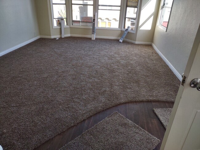 Amplia sala de estar con ventanales y alfombra nueva - 153 Ximeno Ave