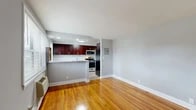 This one-bedroom, one-bathroom unit at 100 Arcadia Rd in Hackensack, NJ offers a well-organized layout across a single floor. Warm hardwood flooring flows throughout the living, dining, and bedroom areas, creating a cohesive and inviting atmosphere. The open-concept living and dining room is bright and functional, with a front entry door featuring a transom window that allows natural light to filter in.

The kitchen is a standout feature, showcasing rich dark-wood cabinetry, granite countertops, a classic white subway tile backsplash, and a peninsula that provides additional workspace and casual seating. Stainless steel appliances — including a gas range, microwave, dishwasher, and refrigerator — complete the modern setup. A window in the kitchen brings in additional natural light.

The spacious bedroom includes two closets, light-toned hardwood floors, and a window with an outdoor view, along with a wall air conditioning unit for comfort. Three closets total are distributed throughout the unit, offering ample storage. The bathroom features full white tile walls, a soaking tub with shower, and a vanity with a clean white countertop. A hallway connects the main living spaces, contributing to the unit's efficient and practical flow.