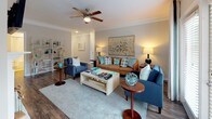 Located at 3112 Maybank Hwy on Johns Island, SC, this single-story residence offers a well-designed layout with consistent finishes throughout. The entryway features rich hardwood-style flooring and crown molding, setting a polished tone that carries through the common areas. A decorative mirror accents the entry hall, which opens toward the living and dining spaces.

The living room is bright and inviting, highlighted by crown molding, large windows allowing natural light, and access to an outdoor area through glass doors. The adjacent dining area features chair-rail wainscoting, crown molding, and natural light from a window with exterior door access, creating an elegant yet functional space.

The kitchen is outfitted with dark espresso cabinetry, granite countertops, a subway tile backsplash, and stainless steel appliances including a refrigerator, range, and microwave. Hardwood-style flooring continues throughout.

Both bathrooms feature dark cabinetry with granite countertops. The primary bath includes a glass-enclosed shower and access to a spacious walk-in closet with built-in shelving. The secondary bath offers a tub-shower combination and a linen closet. Bedrooms are carpeted, include ceiling fans, and are brightened by large windows with outdoor views.