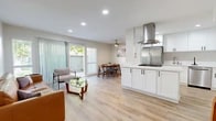 Located at 2130 W Crescent Ave in Anaheim, CA, this 2-bedroom, 1-bathroom home offers a well-designed single-floor layout with a clean, contemporary aesthetic. Light wood flooring flows seamlessly throughout, creating a cohesive and inviting atmosphere.

The open-concept living, dining, and kitchen area serves as the heart of the home. The living room features recessed lighting, a sliding glass door with vertical blinds that opens to an outdoor area, and ample natural light. The kitchen is thoughtfully appointed with white shaker cabinets, black hardware, quartz countertops, a stainless steel refrigerator, gas cooktop with a stainless steel range hood, dishwasher, and a peninsula that provides additional prep space. The dining area sits adjacent to a window with garden views and is accented by a ceiling fan.

The primary bedroom is a comfortable retreat with a ceiling fan, a wide window for natural light, and a sliding-door closet with built-in shelving. The second bedroom is a cozy, simply finished room with the same warm flooring. The full bathroom includes a shower-tub combination with clean white surrounds. Two closets provide convenient storage throughout the home.
