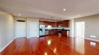 Located at 58 Michigan Ave W in Battle Creek, Michigan, this well-appointed 2-bedroom, 2-bathroom residence offers a thoughtfully designed single-floor layout. The open-concept kitchen and living area is anchored by gleaming cherry hardwood floors that extend throughout the main living spaces. The kitchen is equipped with rich dark-wood cabinetry, dark granite countertops, stainless steel appliances including a French door refrigerator, range, microwave, and dishwasher, alongside a double-basin sink with ample counter space. Recessed lighting illuminates the kitchen and living area, creating a bright and functional environment. The spacious primary bedroom features large windows with city views, polished hardwood floors, a walk-in closet with built-in shelving, and direct access to a well-appointed en-suite bathroom. The primary bath includes a soaking tub positioned beneath a window with outdoor views, a separate glass-enclosed shower, and a vanity with wood cabinetry. The second bedroom is carpeted and features large windows that fill the room with natural light and city views. A dedicated closet and a hallway connecting all rooms complete the layout, offering both comfort and practicality throughout.