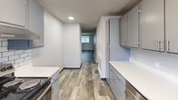 Located at 2719 S Emporia St in Wichita, Kansas, this single-floor unit offers four bedrooms and one bathroom within a practical and well-organized layout. The galley-style kitchen features gray cabinetry with brushed nickel hardware, white countertops, and wood-look plank flooring that extends into the main living area. The kitchen connects seamlessly to a spacious living area, which is finished with the same durable wood-look flooring and neutral gray walls beneath a textured ceiling.

Each of the four bedrooms is carpeted and equipped with a ceiling fan, providing comfort and airflow year-round. Several bedrooms feature windows that allow natural light to fill the space, while closets with built-in hanging rods offer functional storage. The generously sized primary bedroom includes direct access to both a closet and the bathroom, enhancing everyday convenience.

Throughout the unit, a consistent neutral color palette of soft grays and whites creates a clean, cohesive atmosphere. Textured ceilings are present in every room, adding a classic touch. The straightforward single-floor plan ensures easy navigation between the kitchen, living area, and all four bedrooms, making this a highly functional and comfortable living space.
