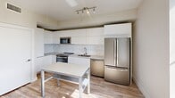 Located at 500 North Andrews Avenue in the heart of Fort Lauderdale, FL, this two-bedroom, one-bathroom residence offers a thoughtfully designed layout with clean, contemporary finishes throughout. Light wood-style flooring runs continuously across the entire space, lending warmth and visual cohesion to each room.

The kitchen serves as a standout feature, equipped with full-size stainless steel appliances including a French door refrigerator, dishwasher, and range. Flat-front white cabinetry extends floor to ceiling, maximizing storage, while a marble-look tile backsplash adds a refined touch. Track lighting illuminates the space efficiently, and a movable island provides flexible prep and dining options.

The primary bedroom is a well-proportioned retreat with neutral wall tones, recessed ceiling details, and direct access to the bathroom. The second bedroom offers a clean, versatile space with recessed lighting and the same consistent flooring found throughout.

The bathroom is finished in a bright, minimalist style with marble-look tile surrounding a full soaking tub and shower combination, a white vanity with ample countertop space, and a large backlit mirror that enhances the sense of openness.

Neutral beige walls throughout the residence create a calm, move-in-ready atmosphere that is both functional and modern — well-suited for everyday living in one of Fort Lauderdale's central neighborhoods.
