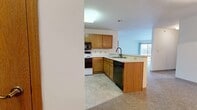 Located at 100 Corrina Blvd in Waukesha, Wisconsin, this single-floor, two-bedroom, two-bathroom home offers a well-organized and functional layout. The kitchen is equipped with warm oak cabinetry, a full suite of appliances including a refrigerator, electric range, built-in microwave, and dishwasher, along with a peninsula that opens toward the living area. The living room is generously sized, featuring plush carpet, baseboard heating, and a sliding glass door that fills the space with natural light and provides outdoor access. The spacious primary bedroom includes a ceiling fan, natural window light, baseboard heating, and direct access to a large walk-in closet outfitted with wire shelving on multiple walls. A second well-sized bedroom also features a ceiling fan and carpeted flooring. Both bathrooms are cleanly appointed, with one featuring a full tub/shower combination, tile flooring, and a wood-trimmed vanity. Three closets throughout the home, including the expansive walk-in, provide abundant storage. The consistent use of neutral tones and carpet across the living spaces creates a cohesive, comfortable atmosphere throughout this practical and well-appointed Waukesha home.