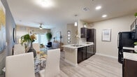 Located at 1420 S Tyler Ave in Loveland, Colorado, this single-story, 3-bedroom, 2-bathroom home offers a thoughtfully designed open-concept layout. Light wood-look flooring flows throughout the main living areas, anchoring a bright and cohesive aesthetic. The kitchen is outfitted with dark espresso cabinetry, granite-style countertops, black appliances, and a peninsula with a sink that opens directly to the dining and living areas — ideal for entertaining. The living room features a ceiling fan, large windows with sheer curtains, and a sliding glass door that invites natural light and outdoor views. The primary bedroom is a comfortable retreat with plush carpet, multiple windows, and a ceiling fan. Additional bedrooms share a similar warm, carpeted design with ample natural light. The bathrooms feature dark cabinetry paired with light countertops and tile surround tub-shower combinations with wood-look flooring. A dedicated laundry room houses a full-size GE washer and dryer alongside the water heater, adding everyday convenience. The home also includes a closet for additional storage. Clean lines, neutral tones, and functional design make this Loveland residence a practical and comfortable place to call home.