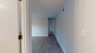 Located at 248 Amherst Rd in Sunderland, Massachusetts, this single-floor unit offers a clean, updated interior with a thoughtfully laid-out floor plan. The main living area features smooth hardwood-style flooring, neutral gray walls, and clean white baseboards, creating a bright and airy atmosphere. Natural light filters in through well-positioned windows that frame views of the surrounding wooded landscape, adding a serene, nature-connected ambiance throughout.

The kitchen is outfitted with white shaker-style cabinetry, dark granite countertops, a stainless steel sink with a modern pull-down faucet, and stainless steel appliances including a range and refrigerator. A ventilation fan and ample upper and lower cabinet storage round out this functional cooking space.

The bedroom is carpeted for comfort and features a large window with wooded views, a baseboard heating unit, and a closet, providing a quiet and cozy retreat. The full bathroom includes a tub/shower combination, a white vanity with a mirror, and light wood-look tile flooring, maintaining the unit's consistent clean aesthetic.

Throughout the space, fire safety devices are visibly installed, and baseboard heating is present in multiple rooms. The overall design is simple, practical, and move-in ready, suited for comfortable everyday living.