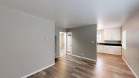 Located at 441 South 5th Street in San Jose, California, this apartment offers three bedrooms, one bathroom, a living room, a kitchen, and four closets — all efficiently arranged on a single floor. The open living area features wood-style flooring in a warm tone, neutral gray walls, and clean white trim, creating a bright and modern aesthetic. The kitchen is thoughtfully designed with white shaker cabinets, dark countertops, stainless steel appliances including a refrigerator and electric range, and a stainless steel sink beneath a window that brings in natural light. Adjacent cabinetry provides additional storage and counter space. The bedrooms are carpeted for comfort and each features windows with blinds that allow natural light while maintaining privacy — one bedroom offers views of surrounding greenery. The bathroom is clean and functional, finished with wood-style flooring, a white vanity, a combined tub and shower with tile surround, and a small window for ventilation. Four closets distributed throughout the unit offer generous storage for its compact footprint. The overall design is clean and updated, making efficient use of the available space.