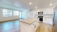 Located at 1610 Orange Ave in Redlands, CA, this well-designed three-bedroom, two-bathroom residence offers a thoughtful single-floor layout with modern finishes throughout. The open-concept kitchen serves as the heart of the home, showcasing crisp white cabinetry, a subway tile backsplash, stainless steel appliances including a range, microwave, and French door refrigerator, and a generously sized center island with a neutral quartz-style countertop — ideal for both meal prep and casual dining. The kitchen flows seamlessly into the living area, which benefits from large windows that invite abundant natural light. Light wood-tone flooring runs throughout the main living and kitchen areas, lending warmth and continuity to the space. The bedrooms are carpeted for comfort, with the primary bedroom offering a spacious walk-in closet complete with built-in shelving and hanging rods. A sliding glass door in one of the secondary bedrooms provides direct outdoor access and additional natural light. Both bathrooms are finished with white cabinetry, quartz countertops, undermount sinks, and full soaking tub-shower combinations with clean tile surrounds. The overall aesthetic is clean, bright, and contemporary, reflecting a move-in-ready home with quality modern touches.