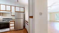 Located at 115 E Broadway in San Gabriel, CA, this single-story 2-bedroom, 3-bathroom unit offers a practical and well-organized layout. The open living room features warm honey-toned hardwood-style flooring and bright white walls, creating a clean, inviting atmosphere with natural light filtering through the windows. The adjoining kitchen is equipped with wood-trimmed cabinetry, a gas range, stainless steel refrigerator, dishwasher, and a double sink beneath a window overlooking the outdoors. Terra cotta tile flooring gives the kitchen a classic, grounded feel. Both bedrooms are carpeted and generously sized, each featuring windows that bring in natural light and views of the surrounding area. The primary bedroom includes a wide sliding-door closet, offering ample storage. Three bathrooms serve the unit, each finished with light-toned vanities, large mirrors, and clean white fixtures — one featuring a bathtub and shower combination. A connecting hallway links the private areas of the unit seamlessly. The overall aesthetic is clean and neutral, providing a versatile canvas well-suited for a variety of interior styles.