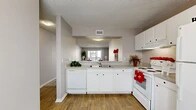 Located at 606 Park Ave in Orange Park, Florida, this single-floor residence offers a well-organized layout featuring two bedrooms, two bathrooms, two hallways, and two closets. The open living room is generously sized, finished with plush wall-to-wall carpet, neutral gray walls, and a textured ceiling. A sliding glass door fills the space with natural light and leads directly to a private outdoor balcony area, ideal for casual outdoor seating. The kitchen features a functional pass-through design with white cabinetry, light countertops, wood-look flooring, and a full suite of white appliances including a refrigerator, electric range, dishwasher, and range hood. A peninsula counter with bar seating connects the kitchen to the adjacent living area, creating a cohesive, open feel. Both bedrooms are carpeted and offer a calm, neutral palette with natural window light. The primary bedroom provides a comfortable, well-proportioned retreat. Each of the two bathrooms includes a tub-shower combination with white tile surround, wood-look flooring, and clean white fixtures. Hallways and closets provide practical storage and circulation throughout. The overall aesthetic is clean, bright, and move-in ready.
