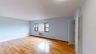 This single-floor unit at Eagle Rock Hicksville in Hicksville, NY offers a well-organized layout that balances living, sleeping, and functional spaces throughout. Polished hardwood flooring in a warm honey tone runs consistently across the living areas and bedrooms, lending a cohesive and clean aesthetic to the interior.

The main living area is generously proportioned, featuring light gray walls, baseboard heating, and a wall-mounted air conditioning unit. A set of black-framed windows allows natural light to filter in, with views of the surrounding brick exterior. An additional room, which functions as a secondary living or dining space, mirrors this design with similar finishes and window placement.

The bedrooms are well-sized, each with black-framed windows that frame views of greenery and the surrounding neighborhood. Multiple closets—including dual closets in one bedroom—provide ample built-in storage throughout.

The kitchen has been modernly updated with white shaker cabinetry, granite countertops, a gray subway tile backsplash, and stainless steel appliances including a gas range, over-range microwave, and dishwasher.

The bathroom features full subway tile wall surrounds in the tub/shower area, gold-toned hardware, and a white vanity with a marble-style countertop, creating a clean and refined finish.