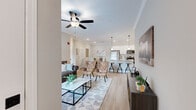 This thoughtfully designed 2-bedroom, 2-bathroom residence offers a comfortable and functional single-floor layout with a seamless open-concept living, dining, and kitchen area. Light hardwood flooring flows throughout the main living spaces, complemented by crown molding and recessed lighting that lend a polished, refined character to the interior.

The kitchen is a standout feature, showcasing white shaker cabinetry, a subway tile backsplash, stainless steel appliances, and a granite-topped island with pendant lighting and bar seating — ideal for casual dining and entertaining. The living room benefits from generous natural light through wide windows with blinds, a ceiling fan, and a warm, inviting atmosphere that connects effortlessly to the dining area.

The primary bedroom is a spacious retreat with plush carpet flooring and ample room for furnishings, while the second bedroom offers versatility as a guest room or home office. Both bathrooms are clean and functional, with the second bath featuring a tiled tub/shower combination and hardwood-style flooring. A dedicated in-unit laundry room accommodates a full-size washer and dryer, adding everyday convenience. A hallway and closet complete the well-organized floor plan, making this a highly practical and comfortable residence.