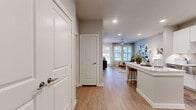 This 1-bedroom, 1-bathroom residence delivers a clean, modern aesthetic throughout its efficiently designed single-floor layout. Light wood-look flooring flows seamlessly across all areas, complemented by neutral gray and white tones that create a bright, cohesive atmosphere.

The open-concept kitchen and living area serves as the heart of the home. The kitchen is outfitted with full-height white shaker cabinetry, a gray subway tile backsplash, stainless steel appliances including a refrigerator, range, microwave, and dishwasher, and a striking waterfall-edge quartz island with bar seating. Recessed lighting illuminates the space efficiently.

The living area benefits from large windows and a glass-panel door that invite abundant natural light and provide outdoor views. A ceiling fan enhances comfort, while the open layout offers flexibility in arrangement.

The bedroom is a comfortable retreat featuring large windows with views and a ceiling fan. It connects directly to the well-proportioned bathroom, which includes a wide white vanity with a quartz countertop, ample storage, and hardwood-style flooring.

Storage is a standout feature, with four closets including a walk-in closet outfitted with multi-level shelving and hanging rods. A dedicated laundry area adds everyday convenience, rounding out this thoughtfully functional residence.