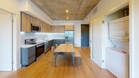 This contemporary apartment, located in the heart of downtown, offers a unique living experience within its 850 square feet. The space is thoughtfully designed with three bedrooms, including a primary bedroom of 180 square feet, two full bathrooms, and two kitchens, providing ample room for both living and entertaining.

The industrial-inspired design is evident throughout, with exposed concrete ceilings adding character and height to the rooms. Large windows in the bedrooms offer city views and flood the space with natural light. The kitchens feature a modern aesthetic with sleek cabinetry, stainless steel appliances, and under-cabinet lighting, creating a stylish and functional cooking area.

The bathrooms boast a minimalist design with large format tiles and glass shower enclosures, enhancing the sense of space. Built-in storage solutions, including closets with adjustable shelving, maximize the available space.

Hardwood floors run throughout the living areas and bedrooms, unifying the design and adding warmth to the industrial elements. The open-plan layout creates a seamless flow between spaces, ideal for modern living and entertaining. Despite its compact footprint, this apartment efficiently utilizes every square foot to provide a comfortable and stylish urban dwelling.