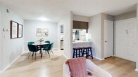 Located on Winters Park Drive in Doraville, Georgia, this single-floor residence offers a thoughtfully designed layout with seamless flow between living, dining, and kitchen areas. Light wood flooring runs throughout the main spaces, complementing a neutral gray and white color palette that creates a clean, contemporary atmosphere.

The living room is a bright, welcoming area anchored by large sliding glass doors with vertical blinds that open to a private balcony, flooding the space with natural light and providing outdoor views. Adjacent to the living area, the dedicated dining space comfortably accommodates a round table and seating, positioned near the kitchen for easy entertaining.

The kitchen features stainless steel appliances, including an electric range, microwave, and refrigerator, alongside a classic white subway tile backsplash and gray cabinetry. A pass-through counter with bar seating connects the kitchen to the main living area, enhancing the open feel.

Two well-sized bedrooms each feature light wood flooring, windows with blinds offering natural light, and ample space for furnishings. The bathroom includes a tub-shower combination with tasteful tile surround, a vanity, and wood-look flooring. Throughout the residence, textured ceilings and clean architectural lines contribute to a cohesive and comfortable living environment.