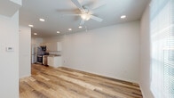 This single-floor, one-bedroom, one-bathroom unit in Metairie, Louisiana, offers a clean, modern aesthetic defined by a neutral color palette and wood-look flooring that runs throughout the entire space. The open layout connects the kitchen directly to the living area, creating a cohesive flow ideal for everyday living.

The kitchen is efficiently designed with white flat-front cabinetry, granite countertops, and a full suite of stainless steel appliances, including a refrigerator, electric range, built-in microwave, and dishwasher. Recessed lighting illuminates the space, complementing the bright, white surfaces.

The living area extends naturally from the kitchen and features a ceiling fan with a light fixture and recessed lighting overhead, contributing to a well-lit, comfortable atmosphere. A window at the far end allows natural light to fill the room.

The bedroom is a well-proportioned, quiet space with a ceiling fan, recessed lighting, and a window fitted with blinds for light control and privacy. The wood-look flooring continues here, maintaining the unit's consistent, polished look.

The bathroom includes a granite-topped vanity, wood-look flooring, and a full tub-shower combination, finished in a clean, all-white surround.